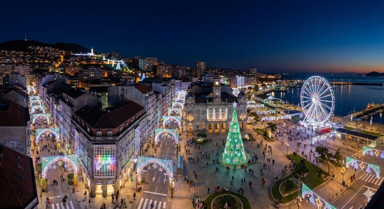 Vista nocturna de Vigo con luces navideñas, árbol gigante y noria junto al puerto